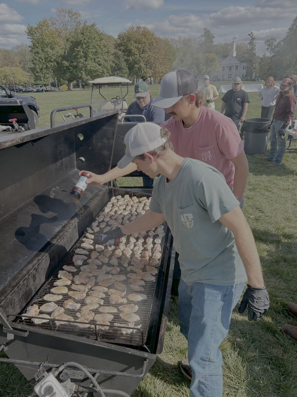 Two Beta Psi brothers cooking on their grill at Harvest Fest.