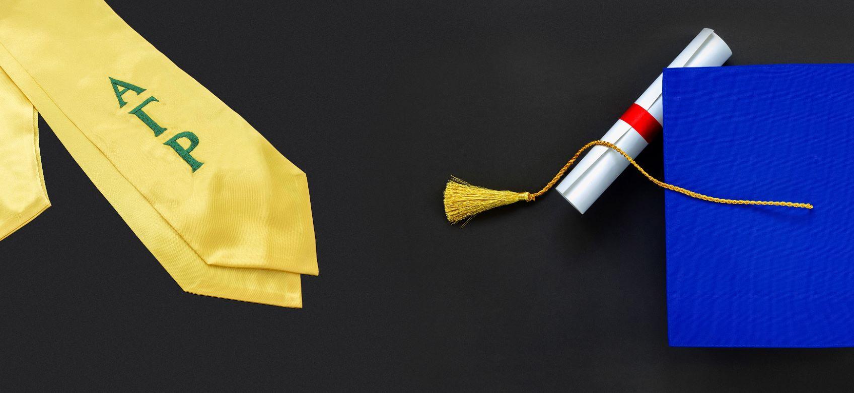 Alpha Gamma Rho sash next to diploma and graduation cap